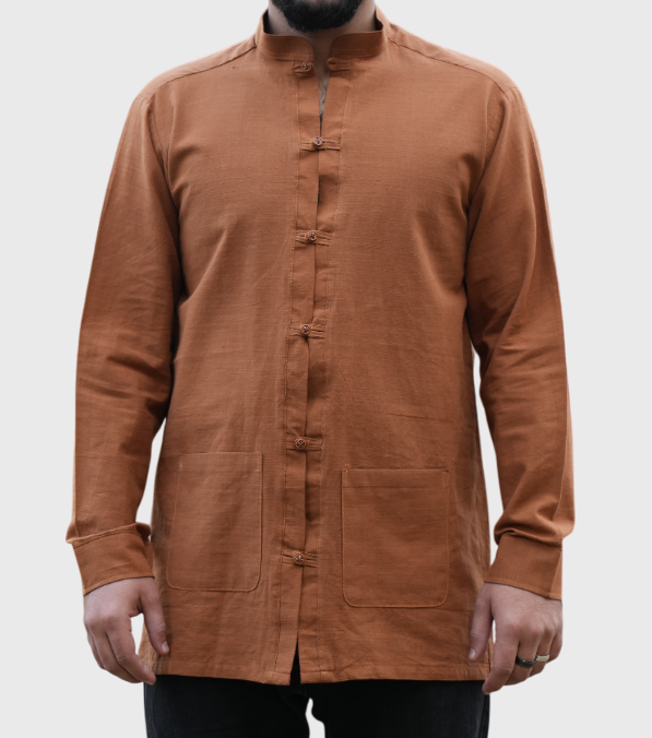 An orange-colored shirt with stylish collars, two bottom pockets, and loop-style buttons, blending vibrant color with unique, functional details for a trendy look.